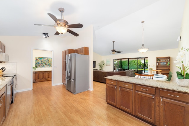 kitchen with ceiling fan, appliances with stainless steel finishes, brown cabinetry, and open floor plan