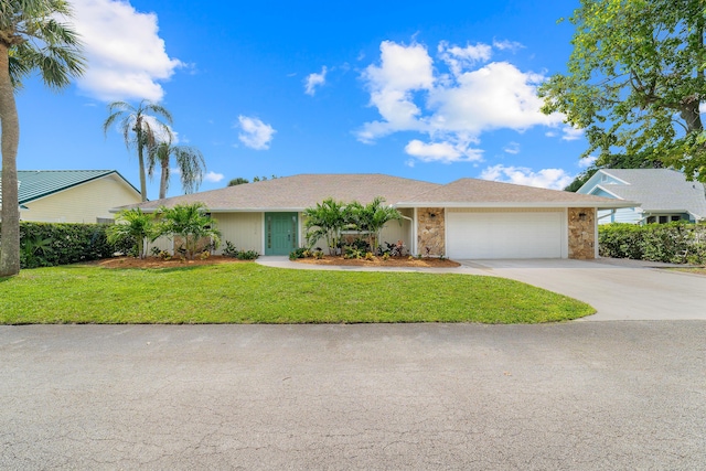 single story home featuring concrete driveway, stone siding, a front yard, and a garage