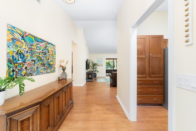 hallway featuring high vaulted ceiling and light wood-type flooring