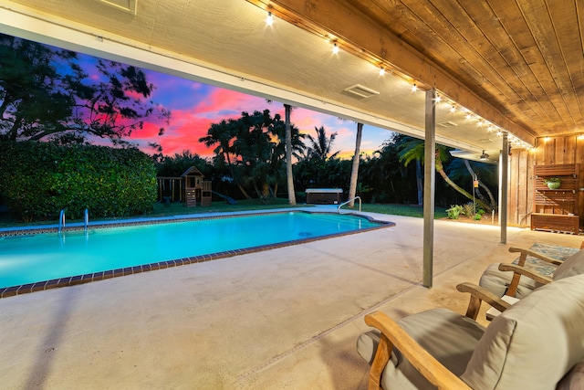 pool at dusk with a patio