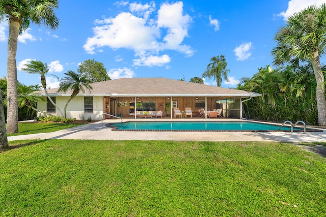 outdoor pool featuring a lawn and a patio