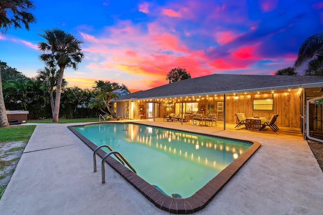 pool at dusk with a patio