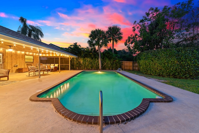 pool at dusk featuring a patio area