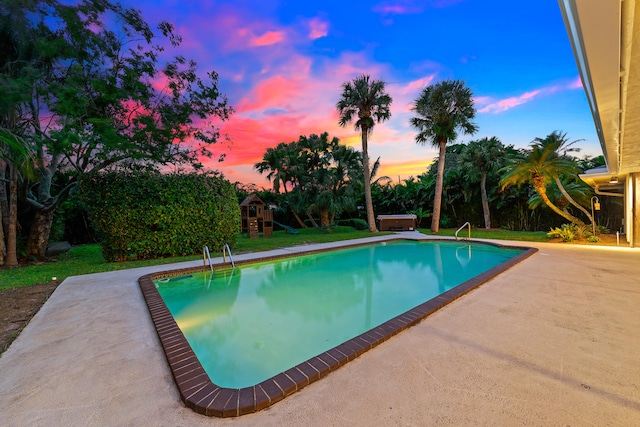 pool at dusk featuring a patio area