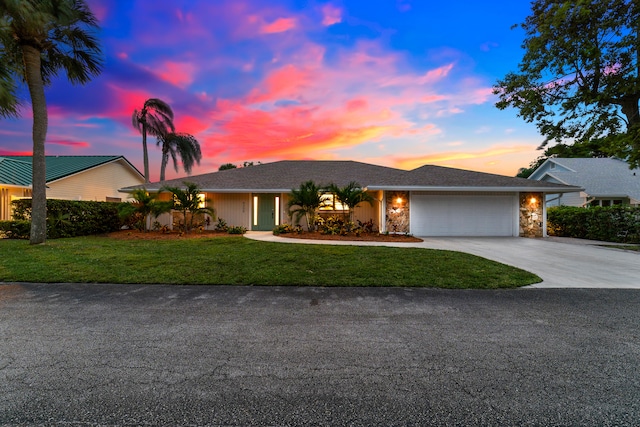 view of front of property featuring a garage and a lawn