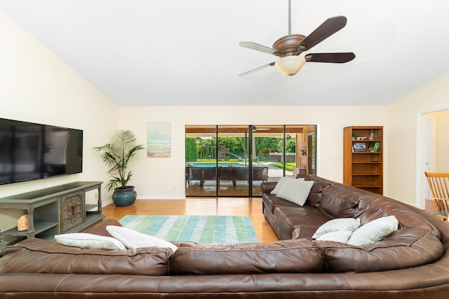 living room with light hardwood / wood-style floors, ceiling fan, and vaulted ceiling