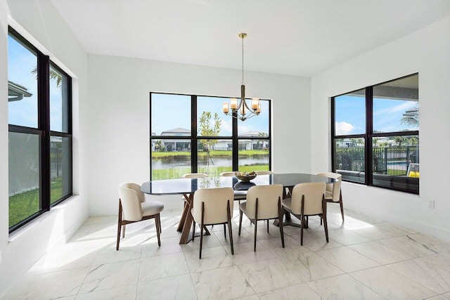 dining space featuring a water view, a notable chandelier, and a wealth of natural light