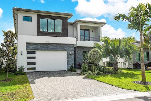 modern home featuring a balcony, a garage, and a front yard