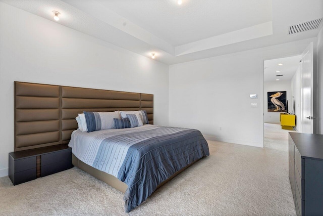 bedroom with a tray ceiling and carpet flooring