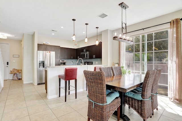 dining area featuring sink and light tile patterned floors