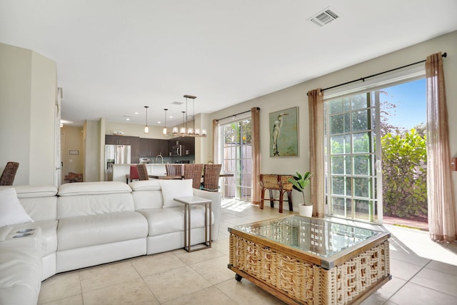 tiled living room with an inviting chandelier