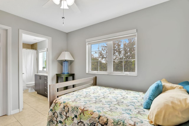 bedroom featuring ensuite bathroom, ceiling fan, and light tile patterned floors