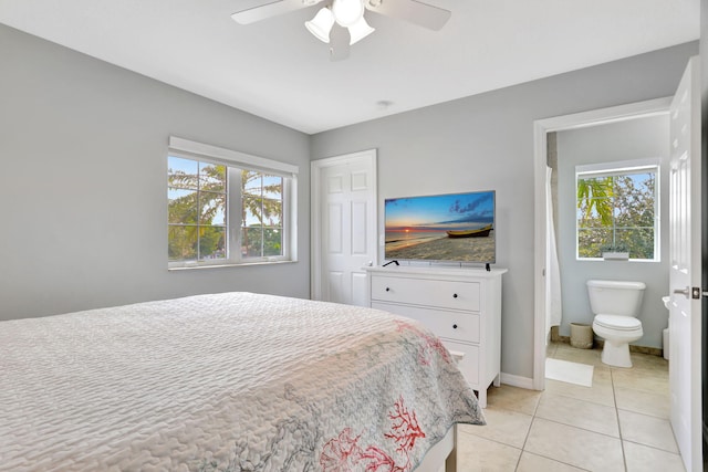 bedroom with ceiling fan, light tile patterned flooring, ensuite bath, and multiple windows