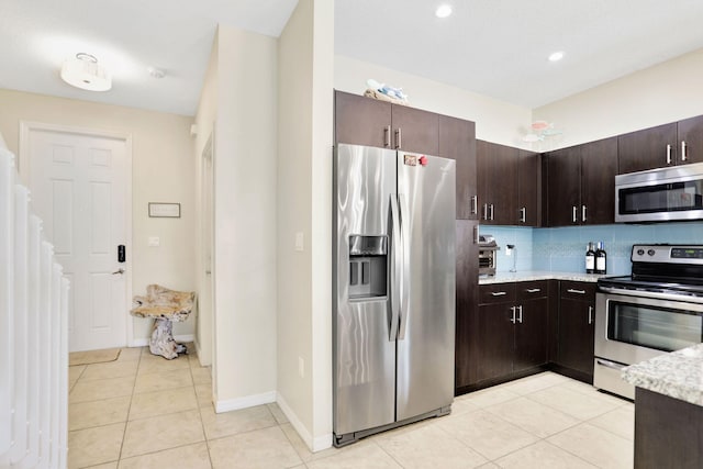 kitchen with backsplash, dark brown cabinets, light tile patterned floors, and appliances with stainless steel finishes