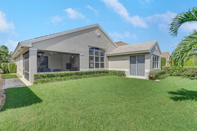 back of property featuring a yard and a sunroom