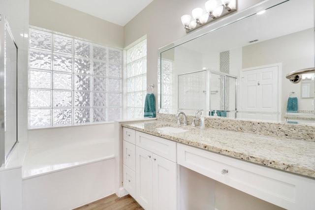 bathroom with vanity, independent shower and bath, and hardwood / wood-style floors