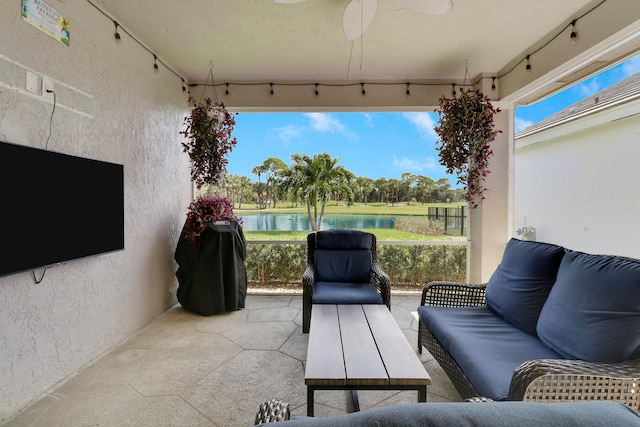 view of patio with a water view and ceiling fan