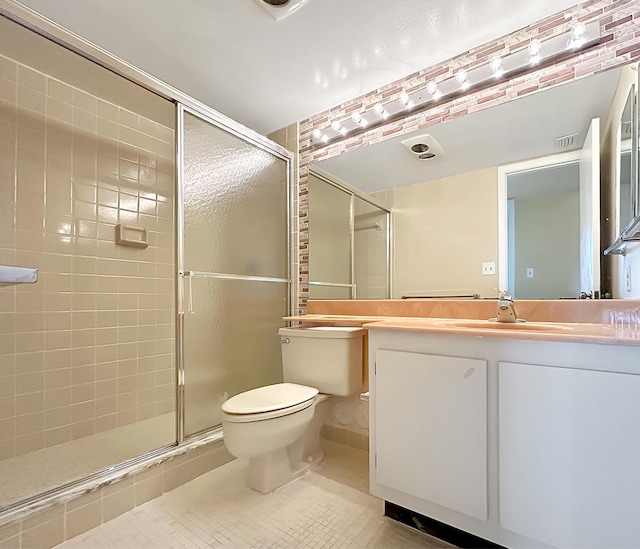 bathroom featuring tile patterned flooring, vanity, a shower with door, and toilet