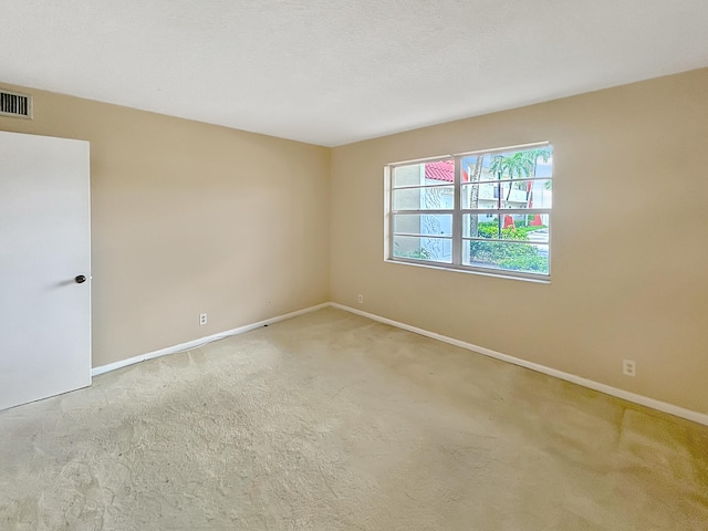 carpeted spare room with a textured ceiling