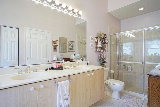 bathroom with tile patterned flooring, vanity, a shower with door, and toilet