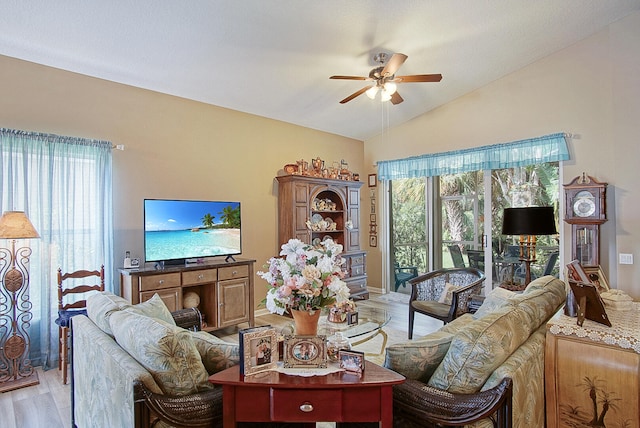 living room with ceiling fan, light hardwood / wood-style flooring, and vaulted ceiling