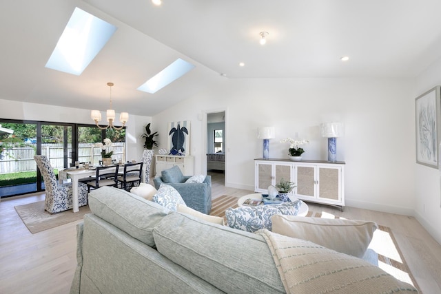 living room featuring vaulted ceiling with skylight, a chandelier, and light wood-type flooring