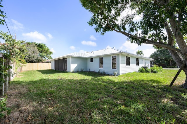 rear view of property featuring a lawn