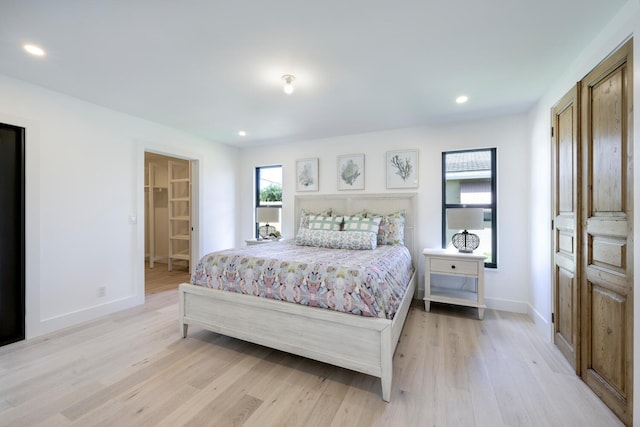 bedroom with light hardwood / wood-style floors and connected bathroom