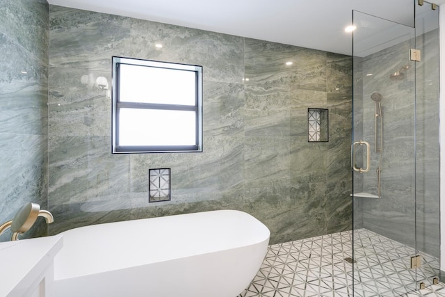 bathroom featuring independent shower and bath, tile patterned floors, and tile walls