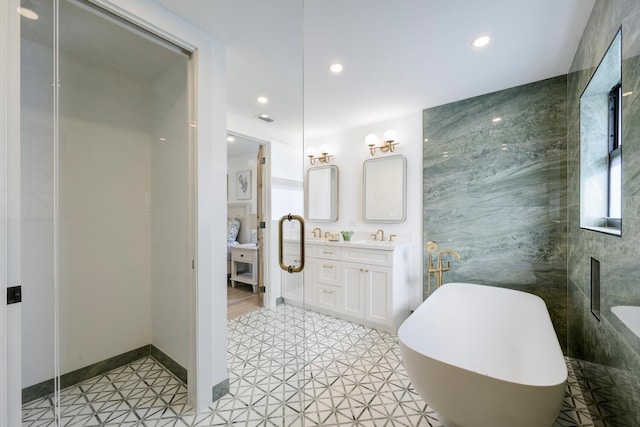 bathroom featuring a bathing tub, vanity, and tile patterned floors