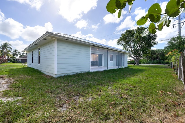 view of side of home with a yard