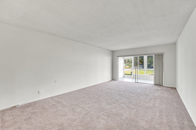 carpeted spare room with a textured ceiling