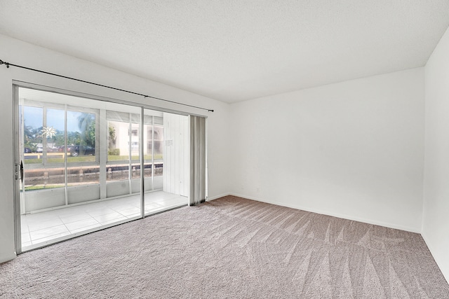 carpeted spare room with a textured ceiling