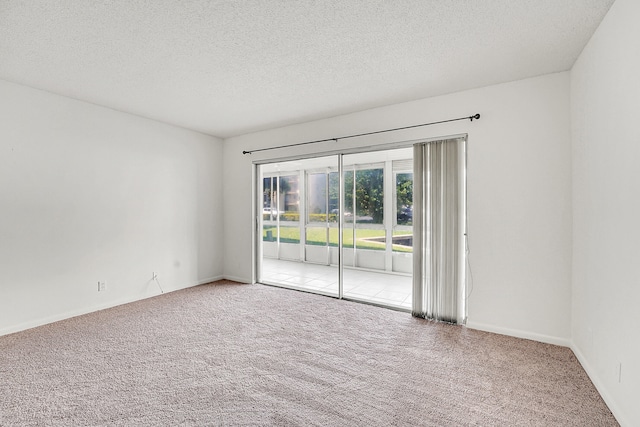 carpeted spare room with a textured ceiling