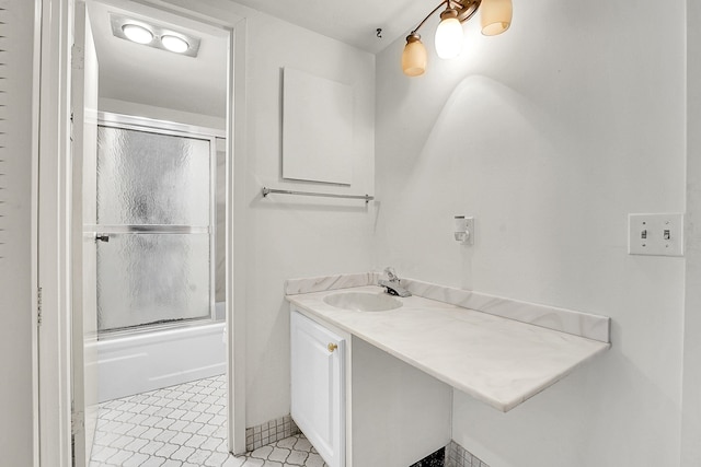 bathroom with tile patterned floors, vanity, and shower / bath combination with glass door