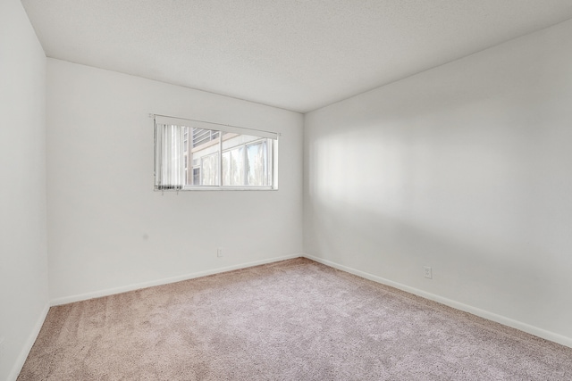 carpeted spare room featuring a textured ceiling