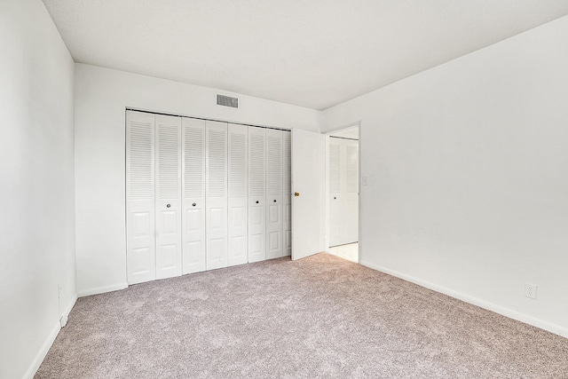 unfurnished bedroom featuring carpet floors and a closet