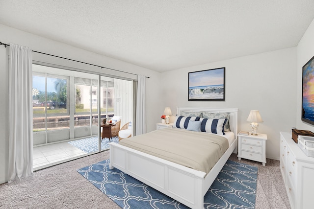 bedroom featuring a textured ceiling, carpet, and access to outside