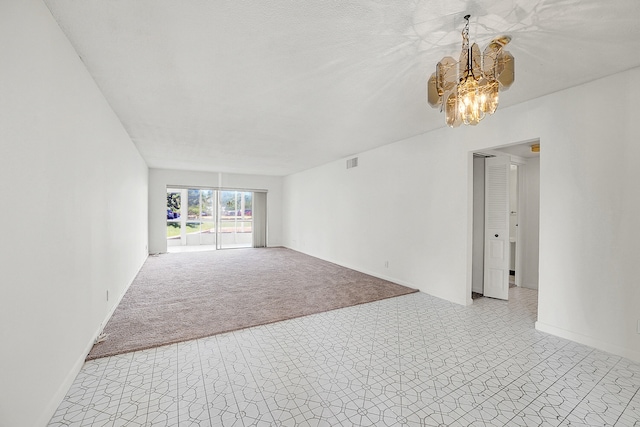 unfurnished living room with a chandelier and light carpet