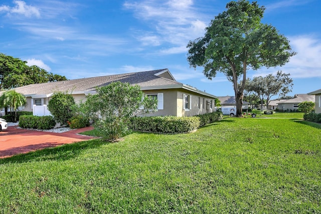 view of property exterior with a lawn, a residential view, and stucco siding