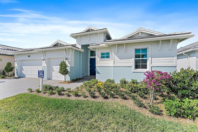 view of front of property with a garage and a front lawn