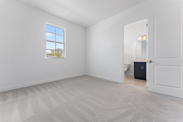 unfurnished bedroom with light colored carpet and ensuite bath