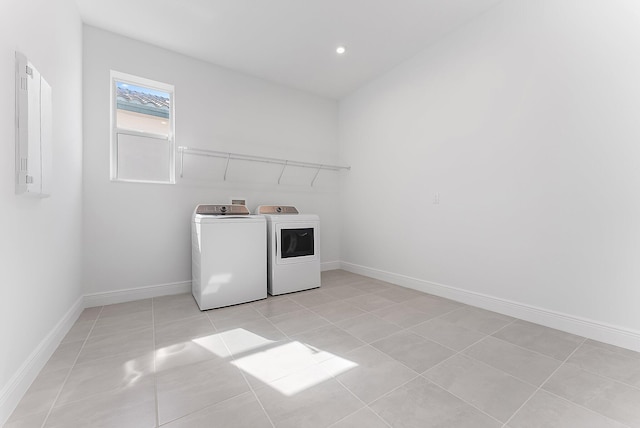 washroom with light tile patterned flooring, electric panel, and washer and clothes dryer