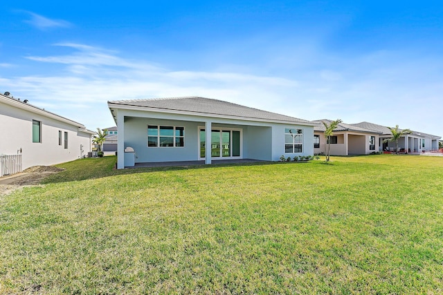 rear view of house featuring a yard