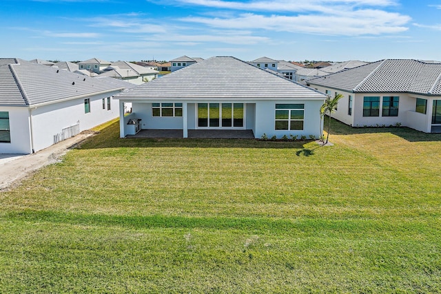 rear view of house featuring a patio and a yard