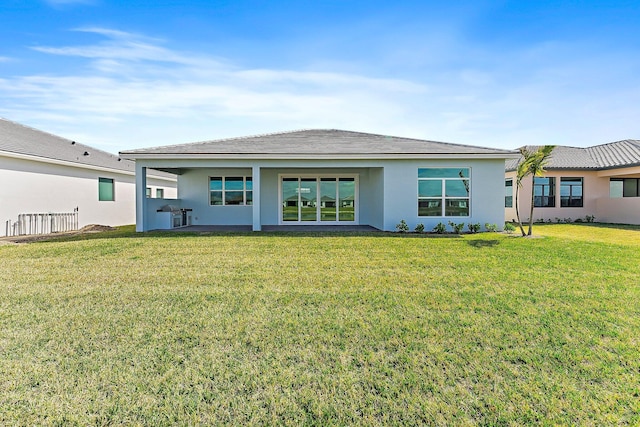 rear view of property with a lawn