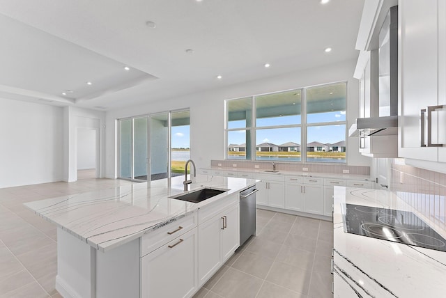 kitchen featuring sink, stainless steel dishwasher, light stone countertops, a kitchen island with sink, and white cabinets