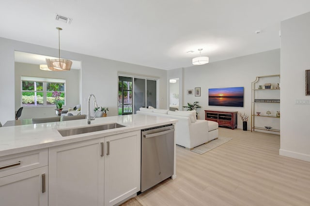 kitchen featuring white cabinetry, dishwasher, light hardwood / wood-style floors, decorative light fixtures, and sink