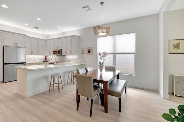 dining area with sink and light hardwood / wood-style flooring