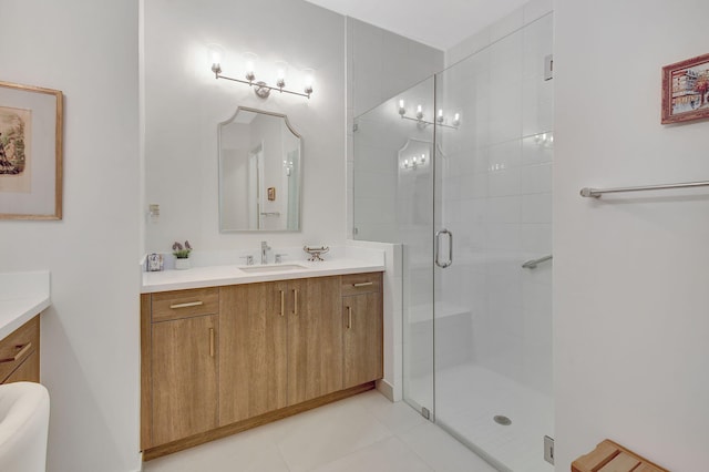 bathroom with a shower with door, vanity, and tile patterned flooring